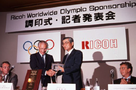 Then IOC President Juan Samaranch and Ricoh President Hamada signed the agreement (at Takanawa Prince Hotel in Tokyo, on September 19, 1989)